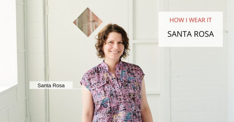 Close up of a woman standing in hallway wearing a pink Santa Rosa Top. The text on the image says "How I Wear It: Santa Rosa". There is additional text labeling the shirt as Santa Rosa.